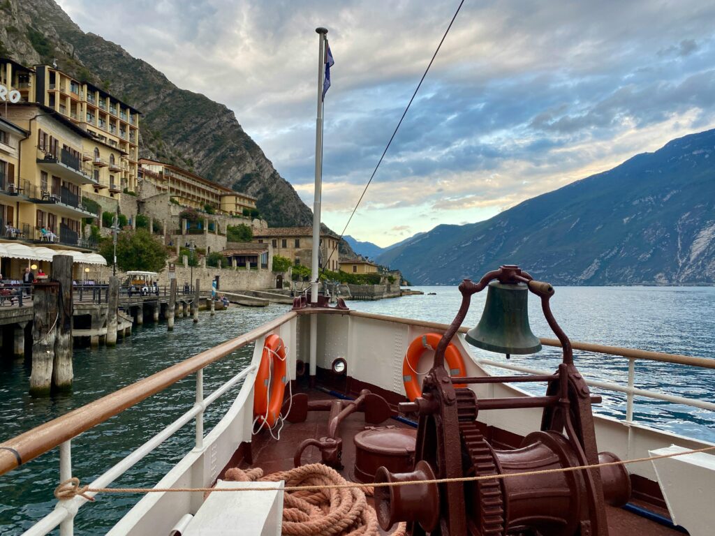 Beautiful view from a ship in Limone Sul Garda, Italy showing waterfront and mountain landscapes.